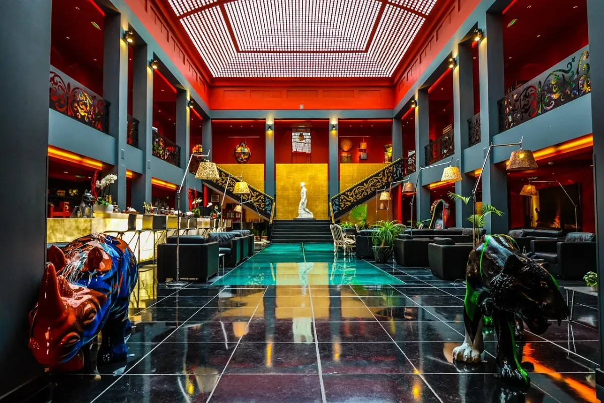 Elegancki salon w stylu art deco z widokiem na miejską ulicę oraz wyeksponowanymi zbiorami sztuki.